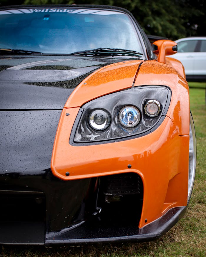 Close-up of an orange VeilSide sports car headlight in Lichfield, showcasing sleek design and vibrant color.